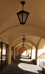 Interior shopping arcade, market gallery of a historic building in St. Petersburg, Russia. A lantern lamp hangs under the arched ceiling. Shadows from the sun.