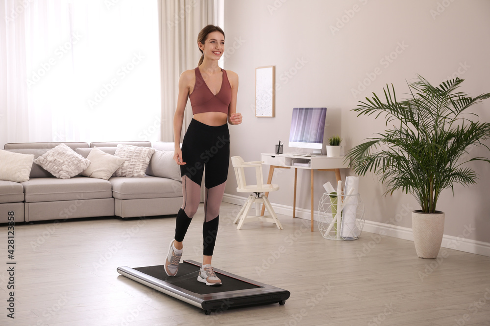 Poster sporty woman training on walking treadmill at home