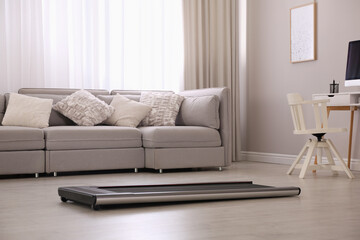 Modern walking treadmill in living room. Home gym equipment