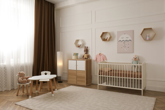 Modern baby room interior with stylish furniture and toys