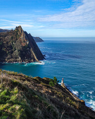 Fototapeta premium San Sebastian, Spain - March 1, 2021: Puntas Lighthouse and the rugged coastline at the mouth of the Rio Oyarzun in Pasajes