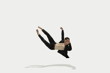 Man in casual style clothes jumping and dancing isolated on white background. Art, motion, action, flexibility, inspiration concept. Flexible caucasian ballet dancer.