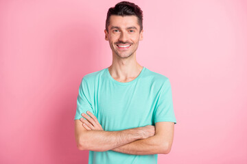 Photo of young happy cheerful good mood smiling positive man with crossed hands isolated on pink color background