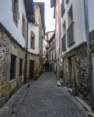 Obraz na płótnie Canvas San Sebastian, Spain - March 1, 2021: Narrow cobblestone streets in the historic fishing village of Pasaia San Juan
