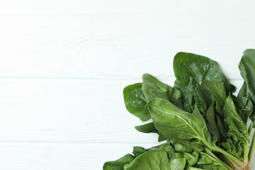 Fresh raw spinach on white wooden background