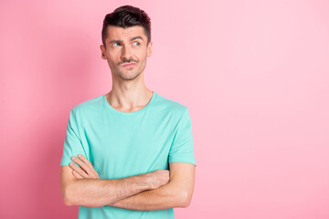 Photo of young confident serious man crossed hands think look empty space isolated over pink color...