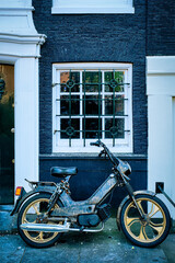 Fototapeta na wymiar Motorbike parked near old house in Amsterdam street,