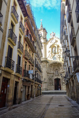Naklejka na ściany i meble San Sebastian, Spain - Jan 10, 2021: the narrow streets and Basilica Church of Parte Vieja in the early morning
