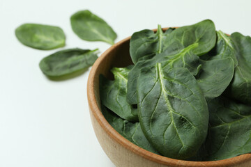 Bowl of spinach leaves on white background