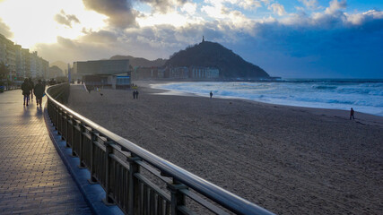 San Sebastian, Spain - Feb 19, 2021: Sunset over Monte Urgull from Zurriola beach