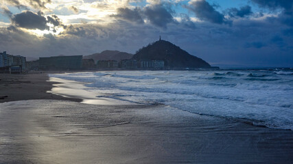 San Sebastian, Spain - Feb 19, 2021: Sunset over Monte Urgull from Zurriola beach