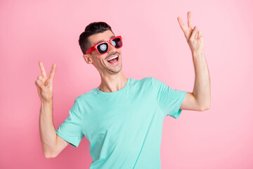 Naklejka premium Photo of young excited man happy positive smile show peace cool v-sign isolated over pink color background