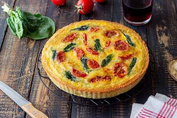 Quiche or pie with tomatoes, spinach and cheese. Healthy eating. Vegetarian food. French cuisine.