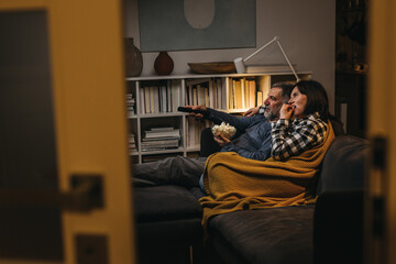 middle age couple enjoying time at home. they watching tv