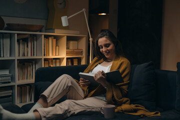 woman reading book at home. evening scene