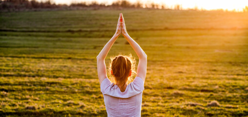 woman in a balancing pose at sunset yoga outdoors