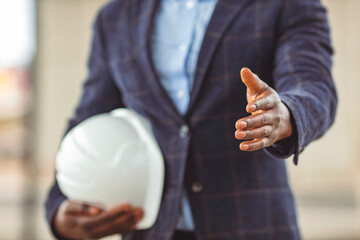 A architect is standing and shaking hands. Copy space for your text. Architect giving hand for a handshake. African American Architect extending hand to shake. concept about agreement, 