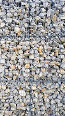 Steine Stein Kies Metall Gitter Netz Gabione Abtrennung Mauer Naturstein Hintergund Struktur Befestigung Schutz schroff felsig grau rau felsig Material Bauwerk Baumterial Garten Park Gestaltung Vorlag