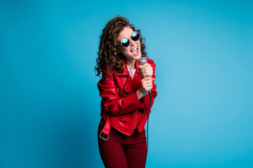 Portrait of pretty wavy hairdo lady two hands hold mic open mouth yell singing isolated on blue color background