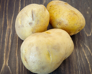 Fresh potatoes isolated on a wooden background. Raw potato food .