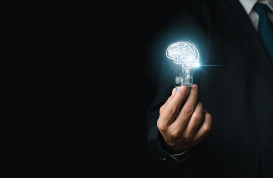 A creative, businessman wear a suit and holding a light bulb with the brain bright to idea new things, dare planning, investing analyzing innovations. Concept knowledge success Inspiration in online.