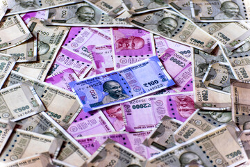 Close-up of one hundred Indian rupees against Indian paper currency background