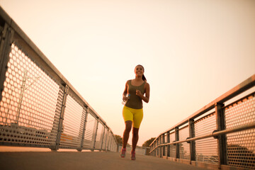 Fototapeta na wymiar She is healthy woman. African woman jogging on the bridge.