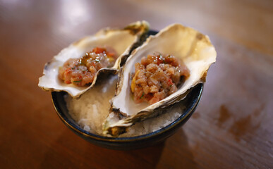 Sea oysters in shells stuffed with fried shrimp meat on a table in a restaurant