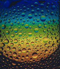 Drops of water on the glass, with the reflection of the rainbow.