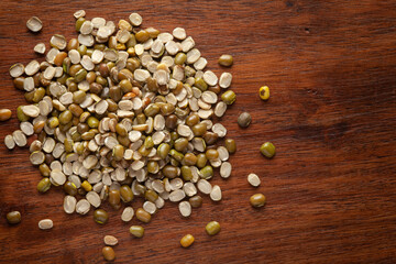 Macro Close-up of Organic split green urad dal (Vigna mungo) cleaned on wooden top background.