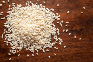 Macro Close up of Organic White  Sesame seeds(Sesamum indicum) polished or white Til without the shell cleaned on wooden top background.