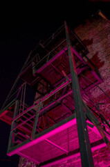iron staircase on a brick wall in the evening, backlit