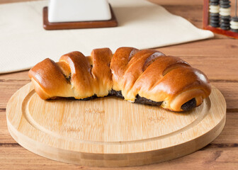 roll with poppy on a round wooden board