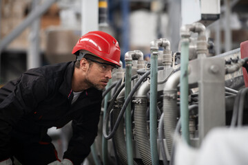  Portrait of worker in factory. Young man with helmet working in factory.