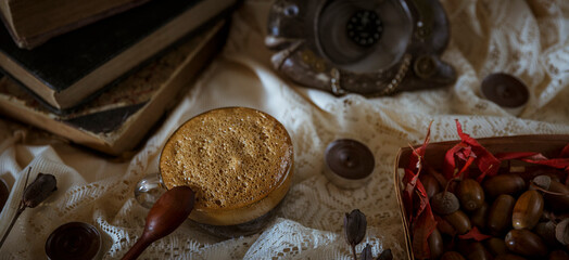 Cup of hot coffee with foam and old books on a vintage background