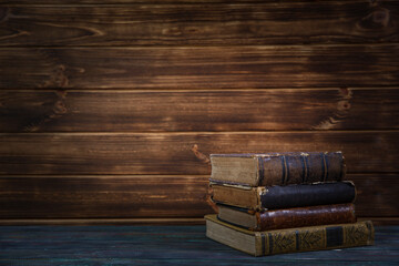 Old books on wooden shelf. Bookshelf history theme grunge background.