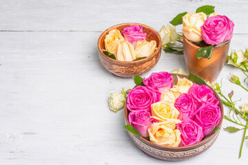Composition of fresh multicolored roses in kitchen utensil