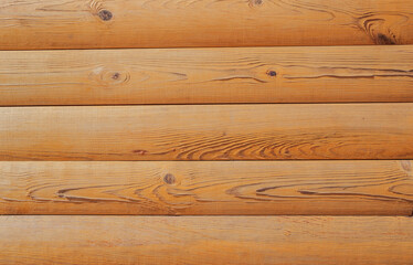 Brown textured background with logs. Wall of log in orange color at home. Wooden logs as rural wallpaper with copy space for text. Pine tree textured board in natural color with paneling view.