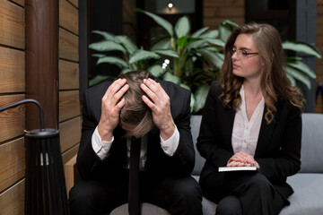 Two business colleagues, a woman reported bad news to an employee, a man in despair