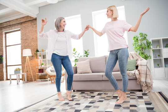 Full body photo of cheerful nice happy old woman young girl dance in living room indoors inside house home