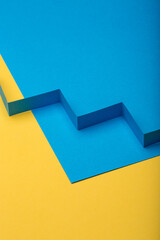 Abstract minimal paper background. Blue zig zag cut out paper stripe on blue and yellow paper background.