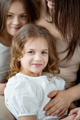 Mom cuddles with her daughters. happy family. 
