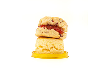 Scones traditional English delicious freshly baked homemade with strawberry jam on isolated white background. Dessert, beverage, and relaxation concept