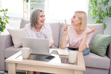 Photo of happy family blonde lady gray haired woman sit sofa use laptop note indoors inside house home flat