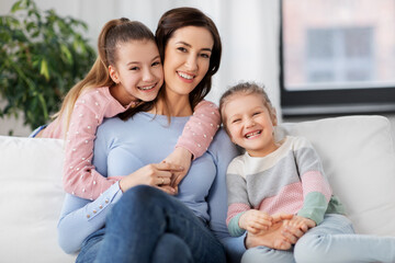 people, family and love concept - happy smiling mother with two daughters at home