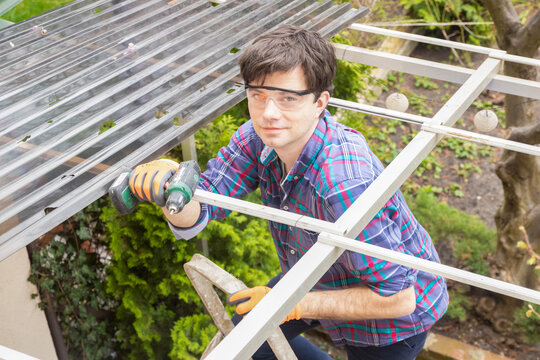 Renovation Of The Roof Made Of Polycarbonate Sheets, Man Repairing The Roof, Holes In Polycarbonate Sheets, Roof Damaged By Hail 