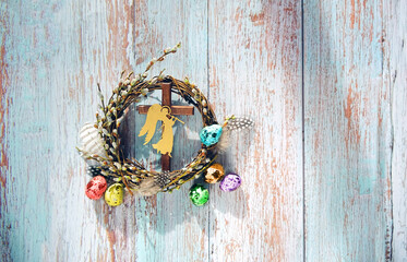 pussy willow wreath, cross, angel decor, colorful eggs on rustic background. Easter holiday background. symbol Christian Orthodox holiday, palm Sunday. spring festive decor