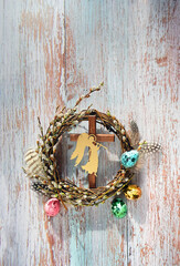 pussy willow wreath, cross, angel decor, colorful eggs on rustic background. Easter holiday background. symbol Christian Orthodox holiday, palm Sunday. spring festive decor