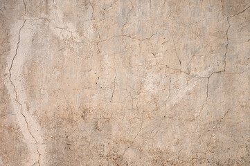 Fototapeta premium Grunge gray background of cracked peeling walls with peeled putty in beige tones.