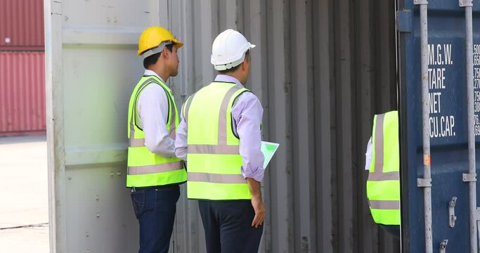 Group of professional dock worker and engineering people wearing hardhat safety helmet and vest working at container yard port of import export. Business teamwork concept